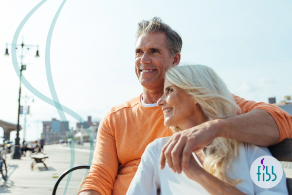 Couple enjoying the beach sitting on bench